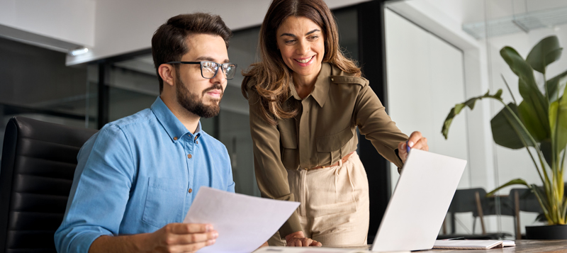 Real estate agents working together on a laptop